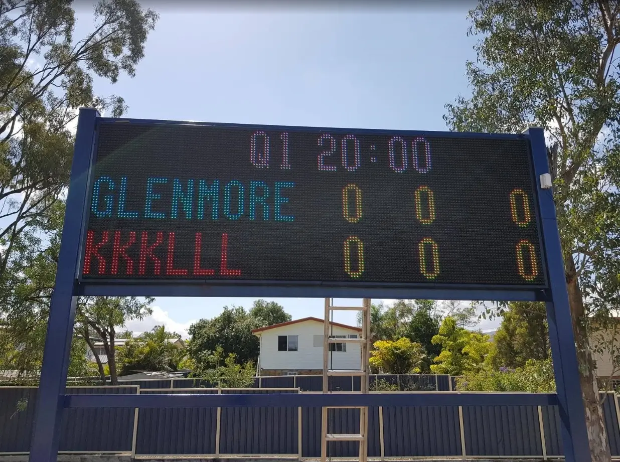 Large outdoor LED scoreboard display board showing team names, scores, and game information for sports fields