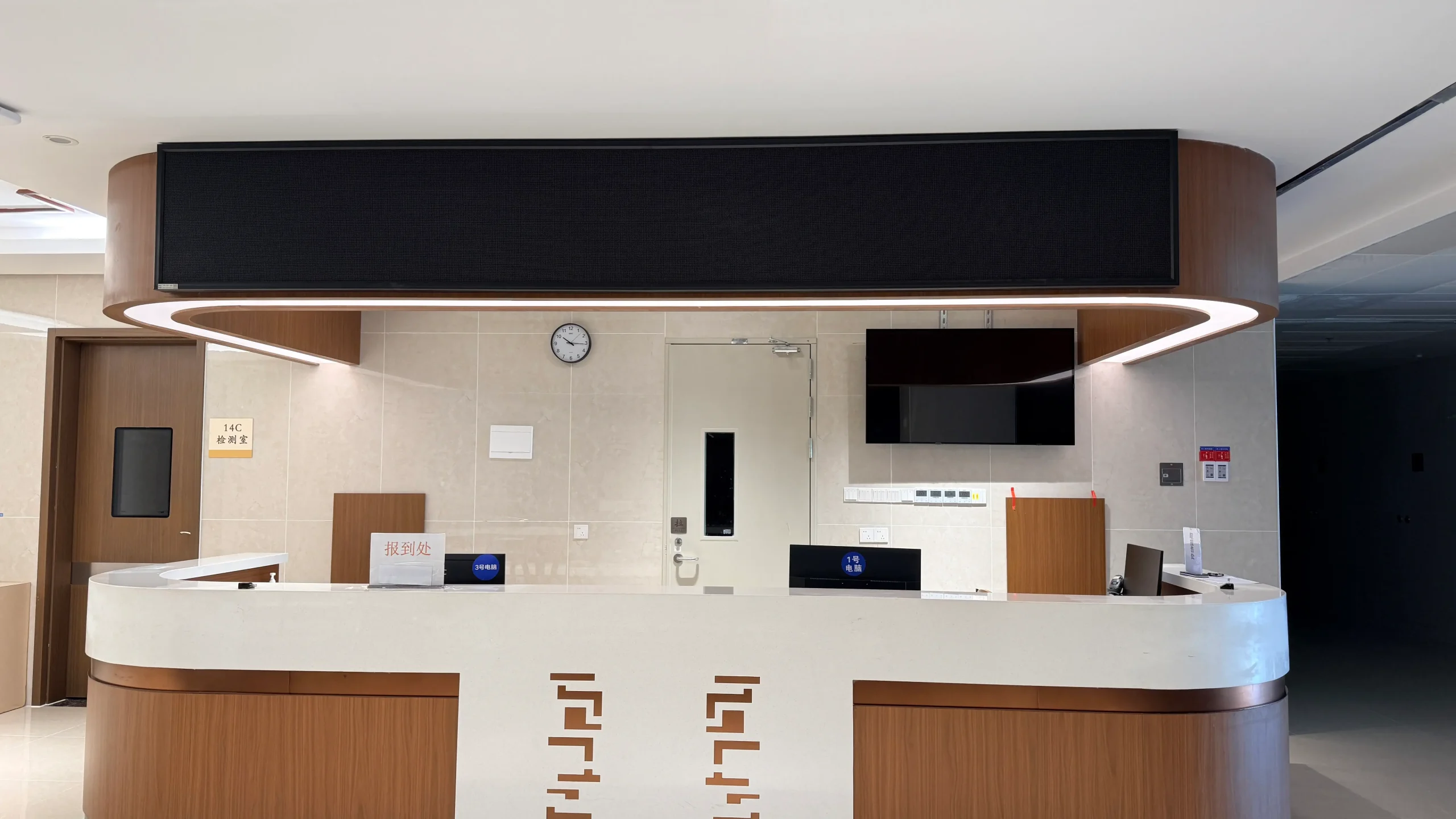 Multiple customized LED queue displays installed above the hospital treatment and waiting area, showing examination rooms and patient information.